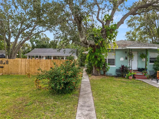 a view of a house with backyard garden and sitting area