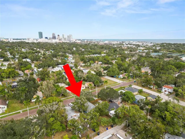 an aerial view of residential houses with outdoor space and trees