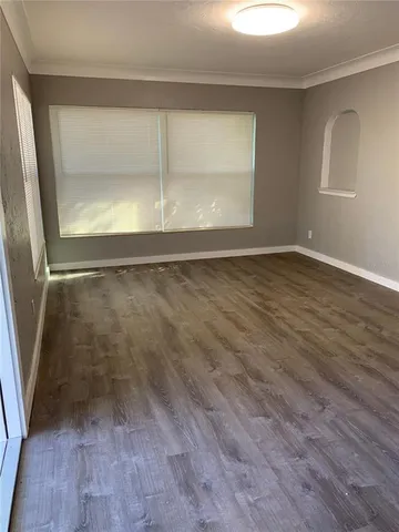 a view of a room with wooden floor and window