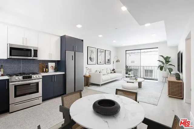 a kitchen with a refrigerator a stove a microwave and living room