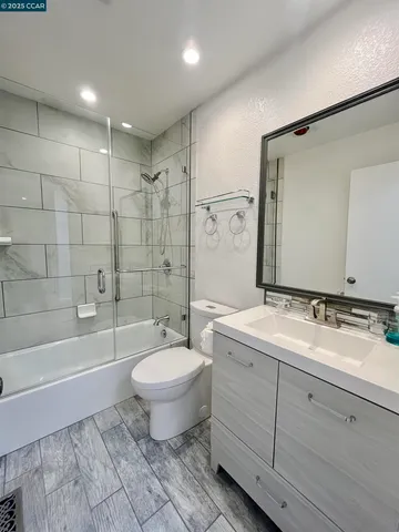a bathroom with a double vanity sink toilet mirror and bathtub
