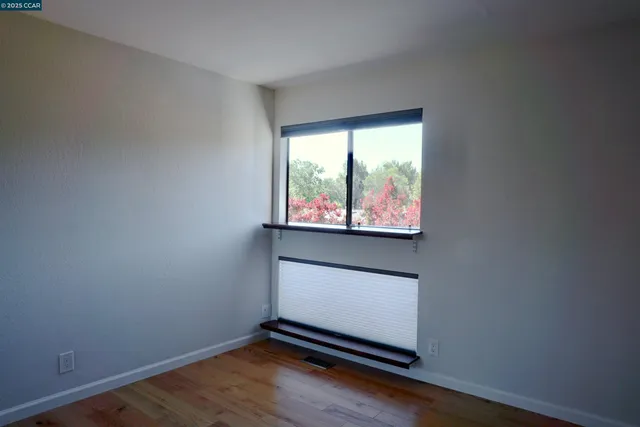 a room with wooden floor and a window