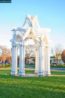 a front view of a building with a garden and statue