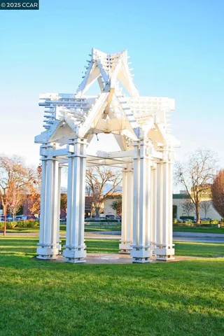 a front view of a building with a garden and statue