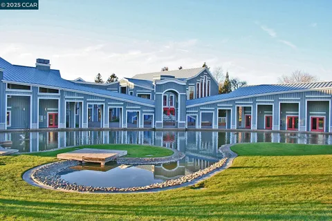 a view of house with a big yard potted plants and large tree