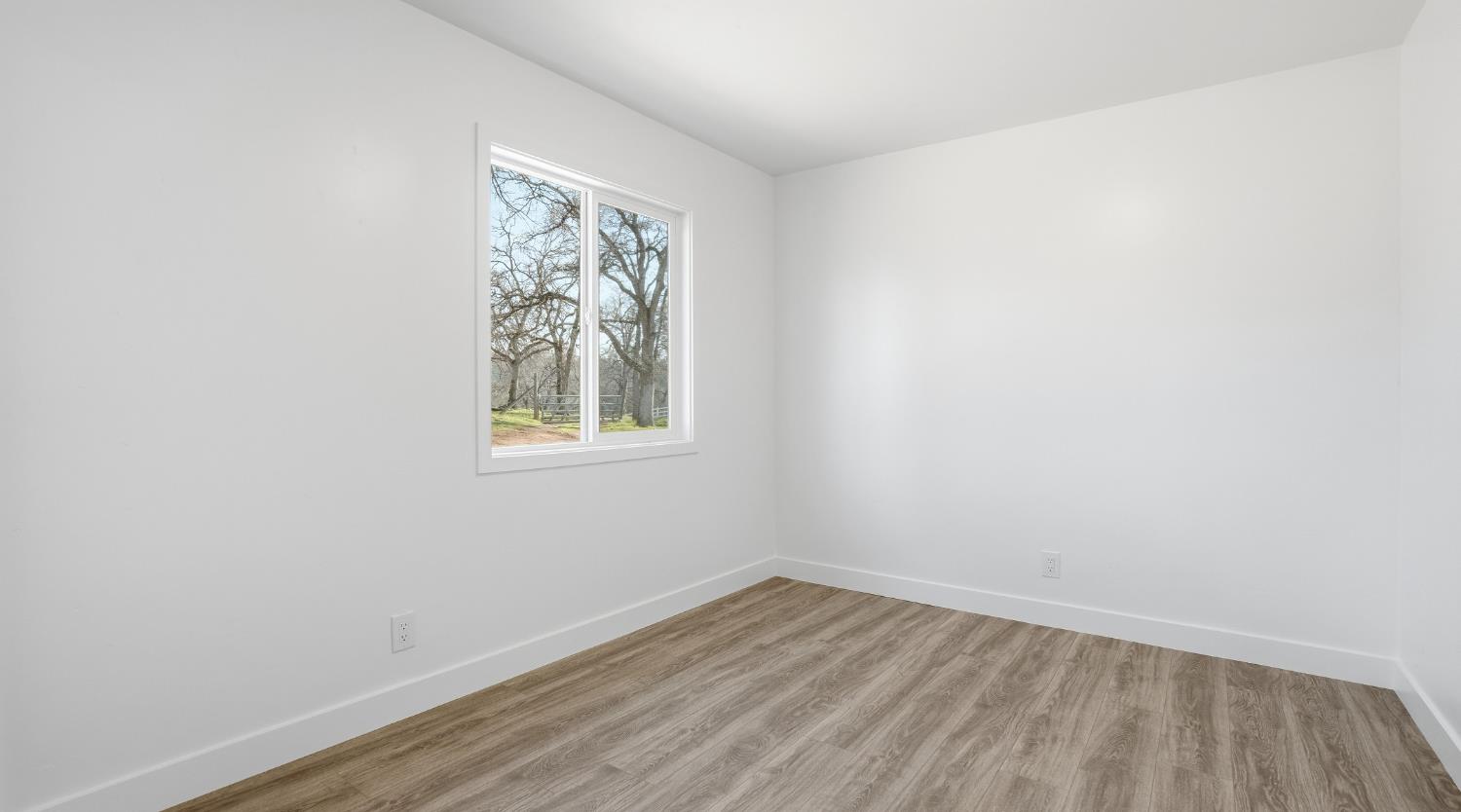 6741 Big Sandy Lane Placerville, CA 95667 - Photo 15 of 25 a view of an empty room with wooden floor and a window