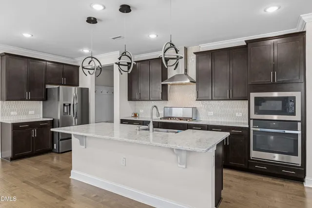 a kitchen with kitchen island stainless steel appliances a sink stove and refrigerator