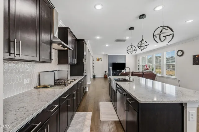 a large kitchen with stainless steel appliances granite countertop a sink a stove and a refrigerator