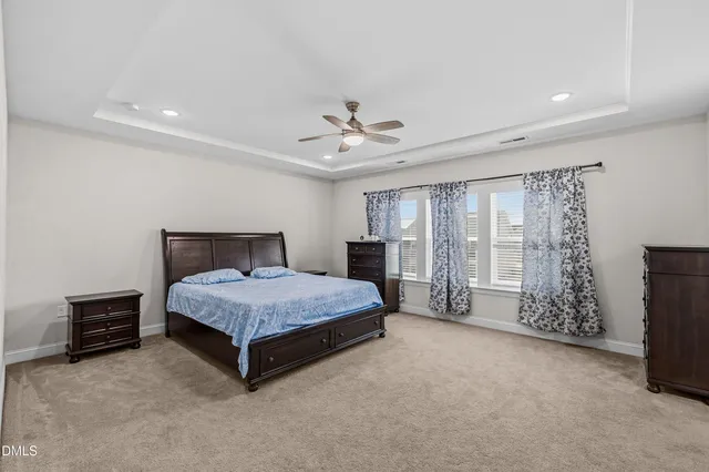 a spacious bedroom with a bed and a chandelier