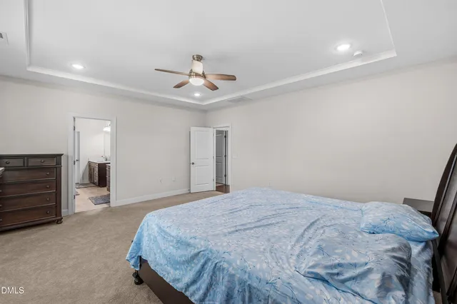 a spacious bedroom with a bed and a chandelier