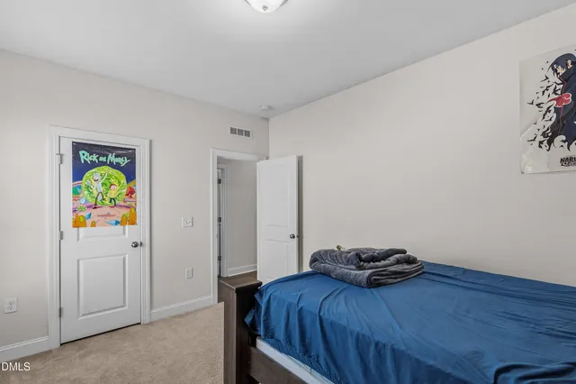 a bedroom with a bed and painting on the wall