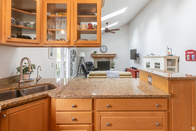 10183 Hickory Point Drive Sandy, UT 84092 - Photo 10 of 36 Kitchen featuring light wood cabinetry with glass-front upper cabinets, a double basin stainless steel sink with a gooseneck faucet, and speckled stone countertops