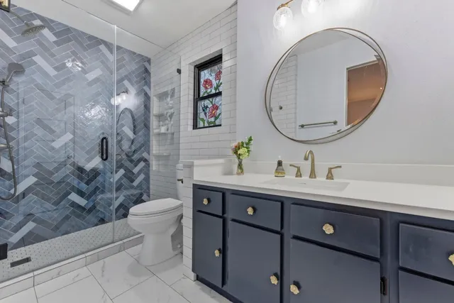 a bathroom with a double vanity sink mirror and toilet