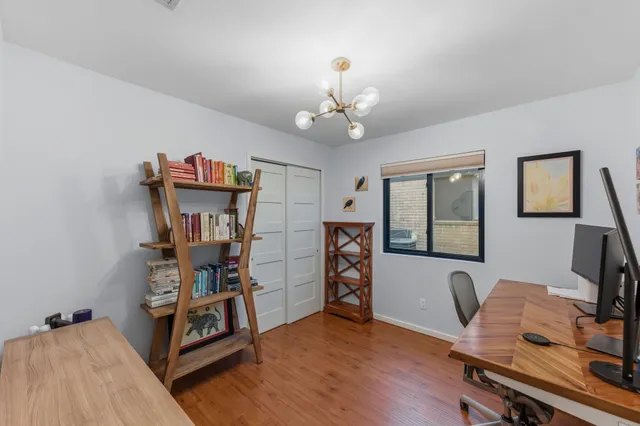 a view of a workspace with furniture and a window