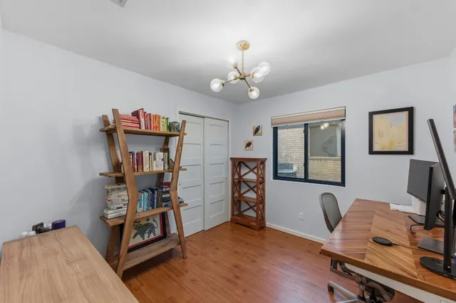 a view of a workspace with furniture and a window