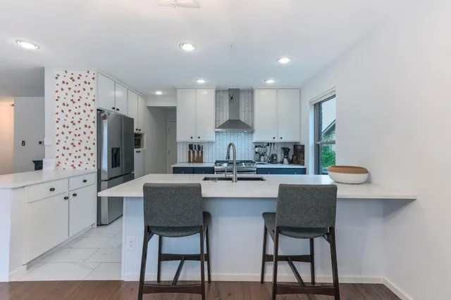 a kitchen with granite countertop white cabinets and chairs