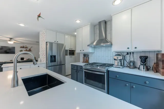 a kitchen with stainless steel appliances a stove a sink a refrigerator and cabinets