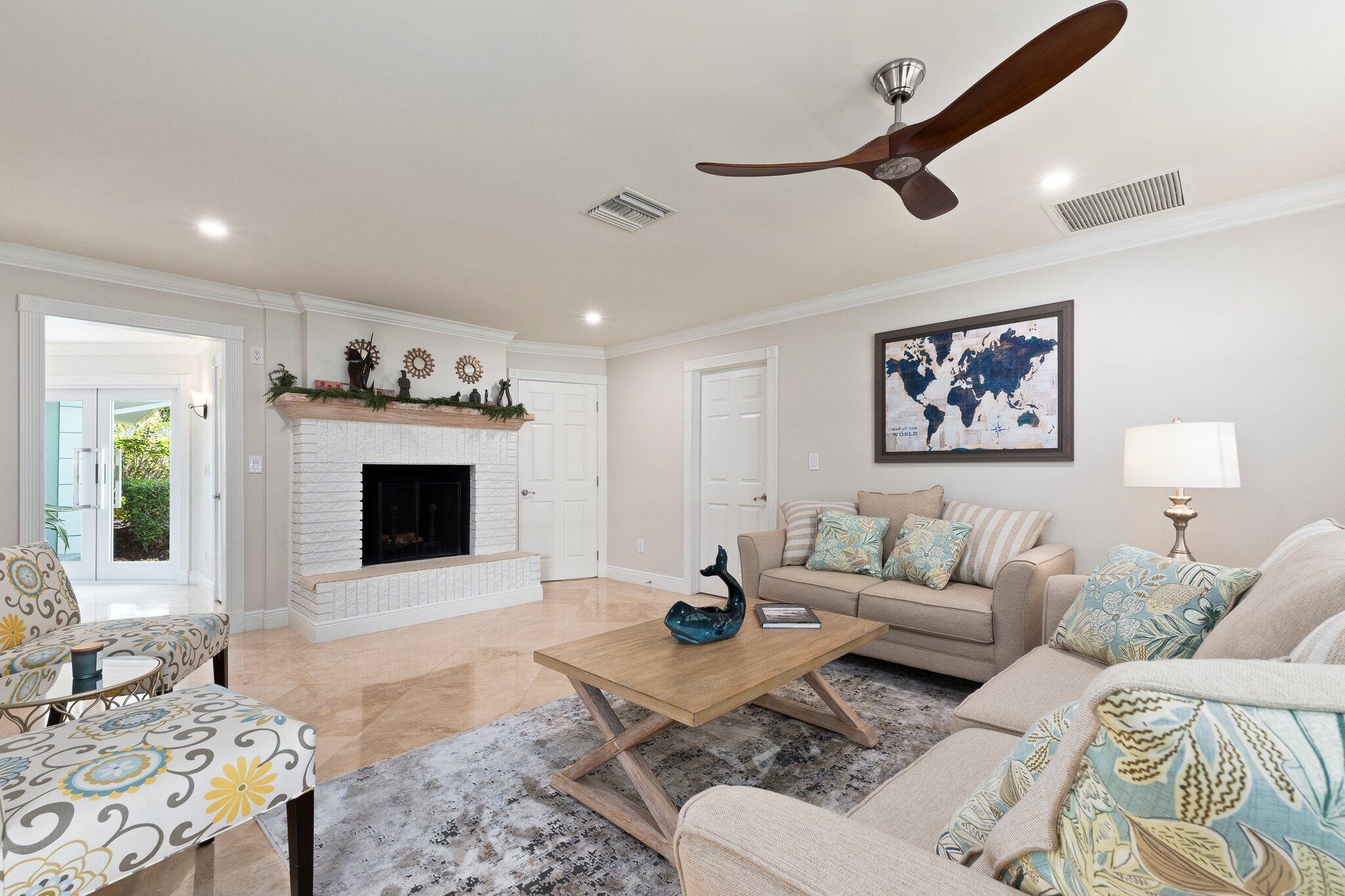 3142 Southeast Fairway West Stuart, FL 34997 - Photo 15 of 38 a living room with furniture a fireplace and a flat screen tv