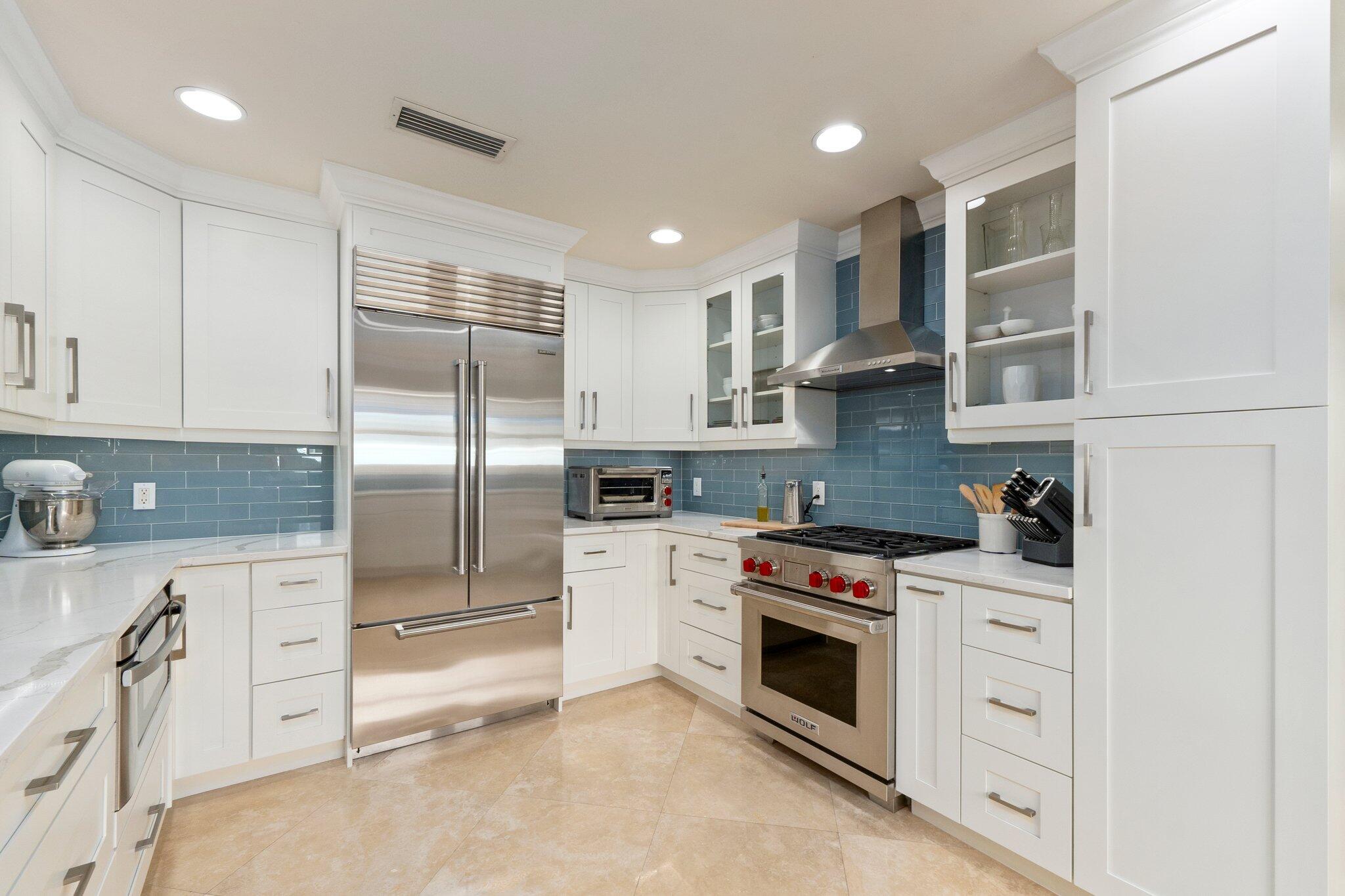 3142 Southeast Fairway West Stuart, FL 34997 - Photo 9 of 38 a kitchen with stainless steel appliances granite countertop a refrigerator and a stove top oven