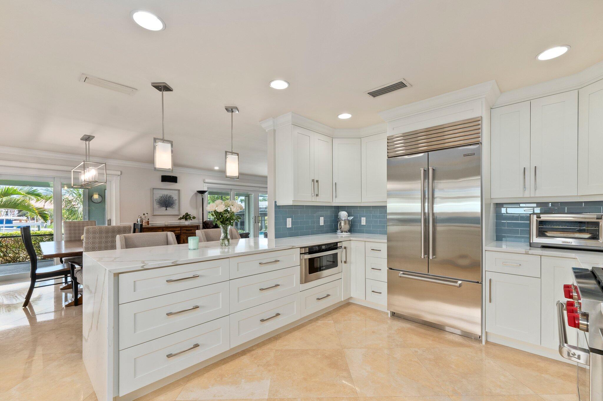 3142 Southeast Fairway West Stuart, FL 34997 - Photo 10 of 38 a kitchen with white cabinets and stainless steel appliances