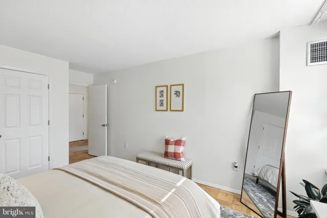a bedroom with a bed and a flat tv screen on the dresser