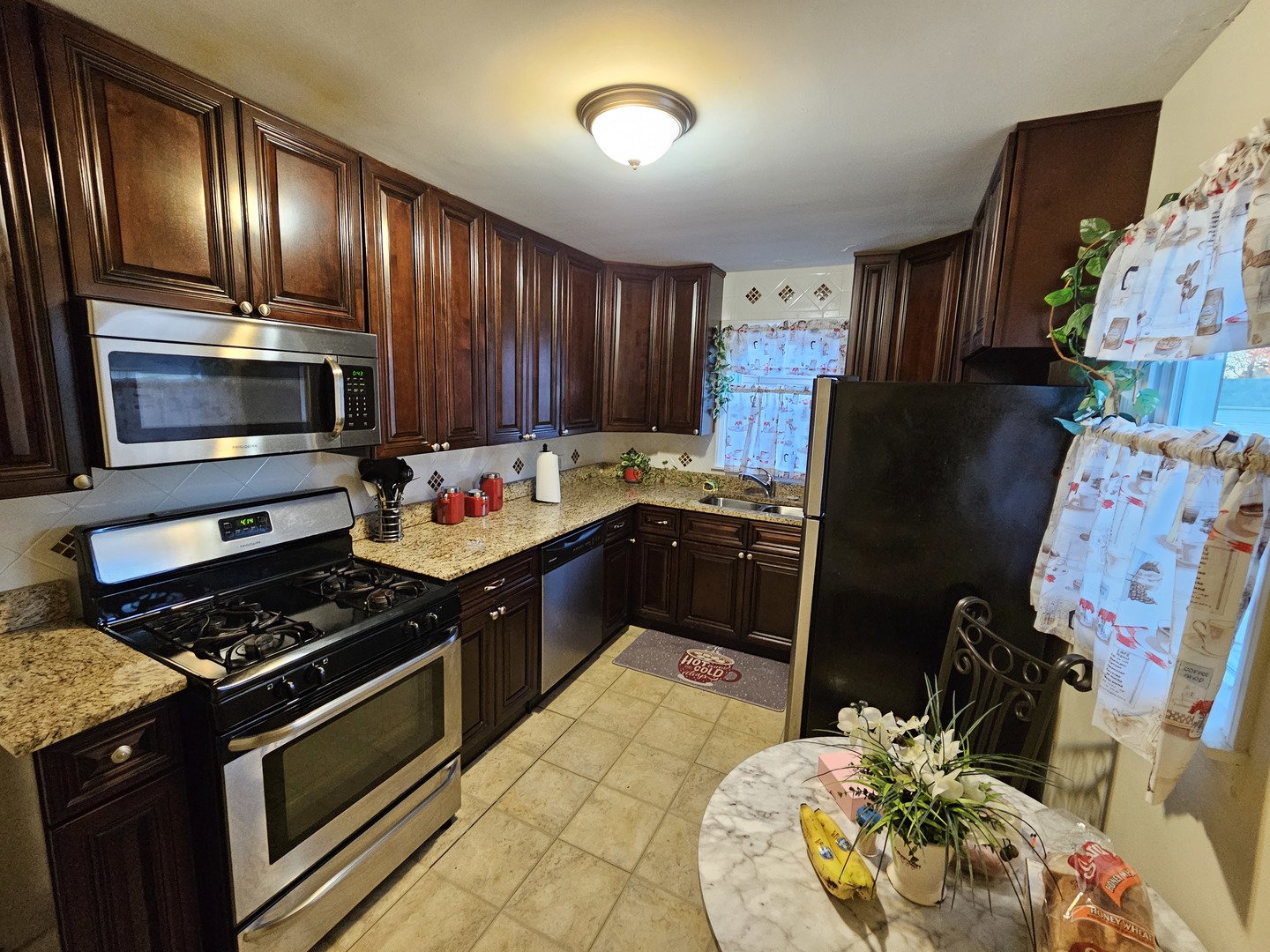 239 South McLean Boulevard Elgin, IL 60123 - Photo 5 of 30 a kitchen with granite countertop stainless steel appliances and wooden cabinets