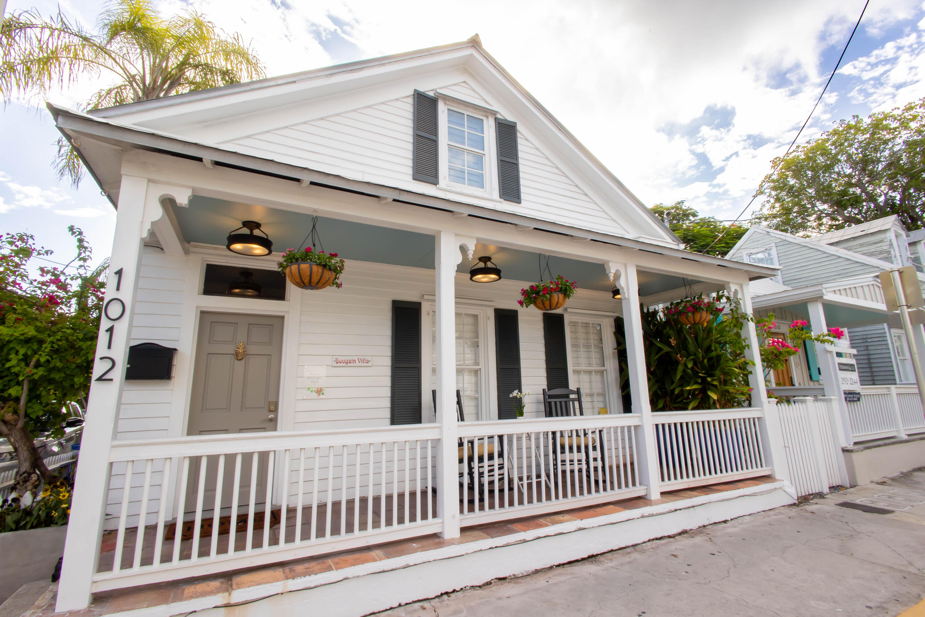 1012 Whitehead Street Key West, FL 33040 - Photo 41 of 49 a view of a white house with large windows and a small yard