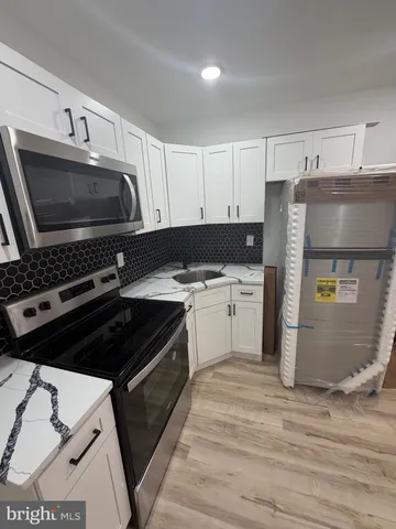 a kitchen with a stove a sink and a microwave