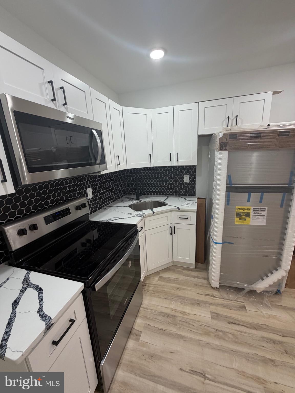 1924 68th Avenue Philadelphia, PA 19138 - Photo 4 of 12 a kitchen with a stove a sink and a microwave