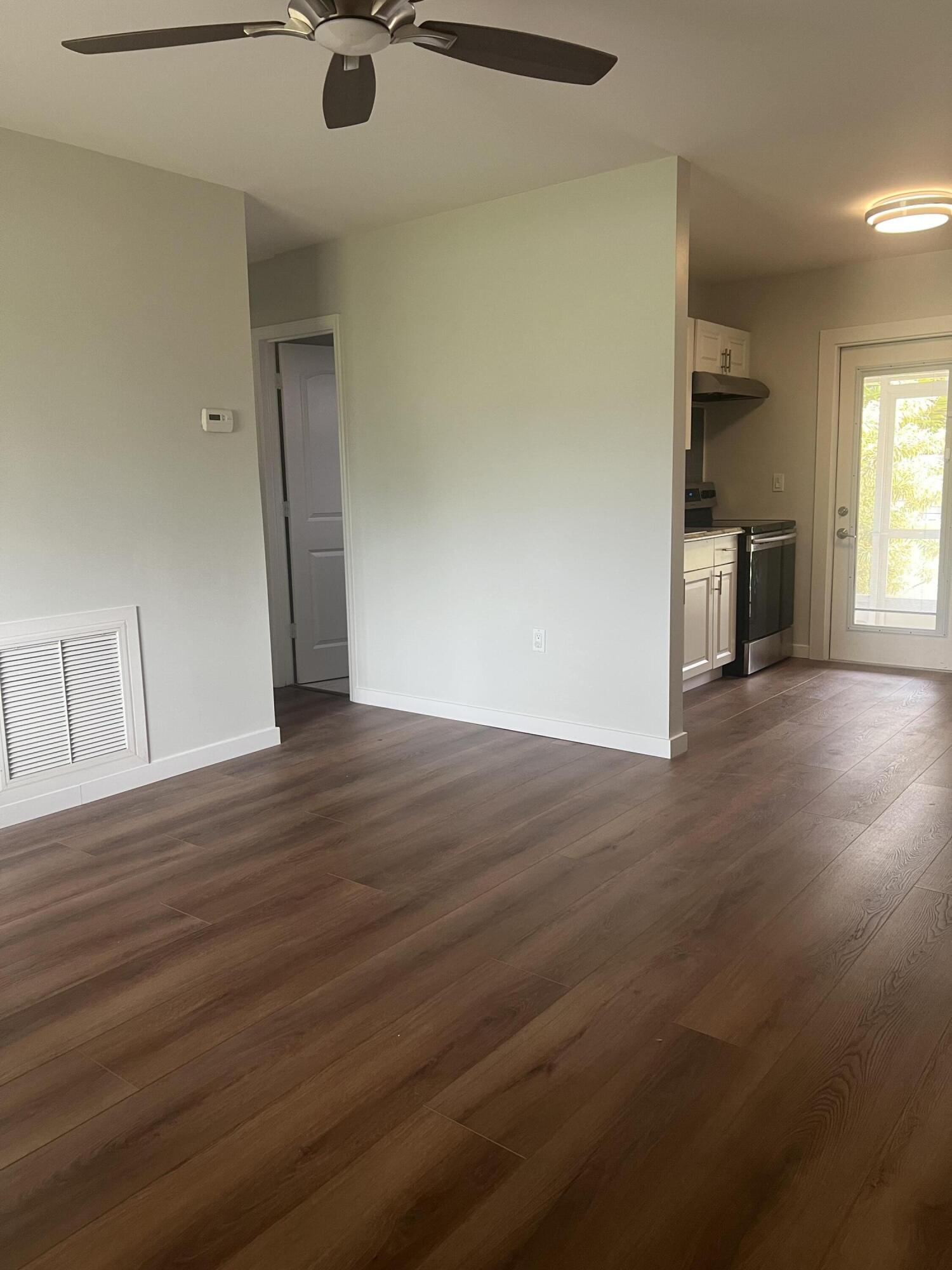 462 Granada Street, Unit A Fort Pierce, FL 34949 - Photo 5 of 10 an empty room with wooden floor and windows