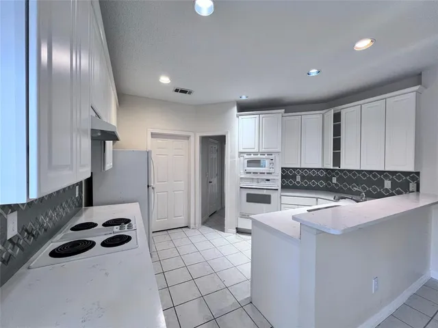 a kitchen with granite countertop a sink and a stove top oven