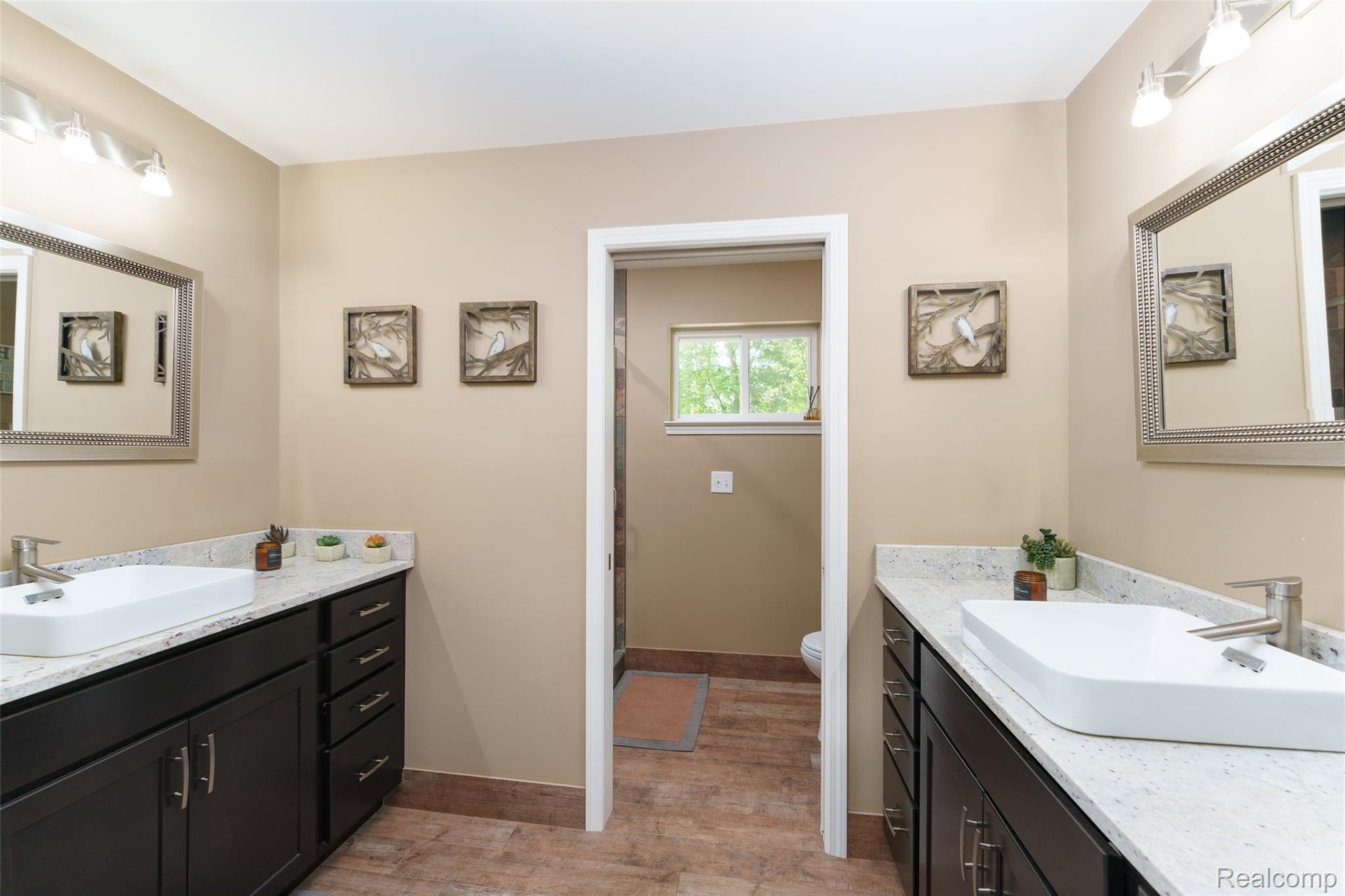 2172 Devonshire Road Bloomfield Hills, MI 48302 - Photo 29 of 45 Two dark wood-finish vanities with vessel sinks and light speckled countertops