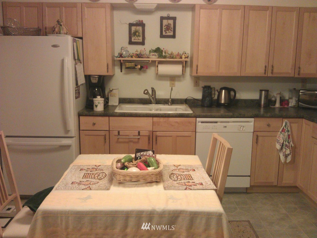 206 Heather Road, Unit 2 Everett, WA 98203 - Photo 11 of 12 a kitchen with stainless steel appliances granite countertop a sink a stove a refrigerator and white cabinets