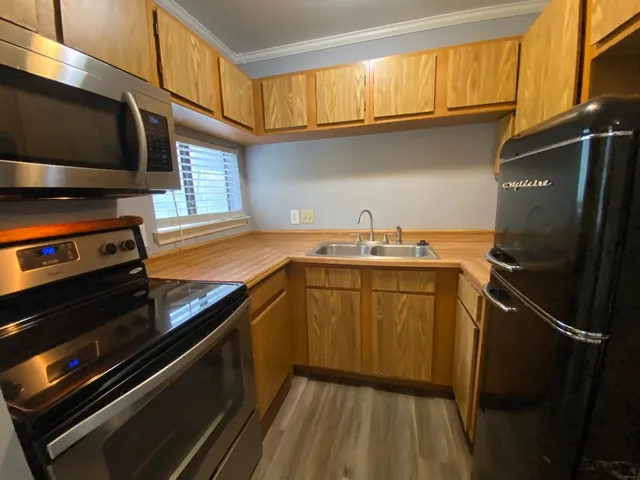 a kitchen with a sink appliances and cabinets