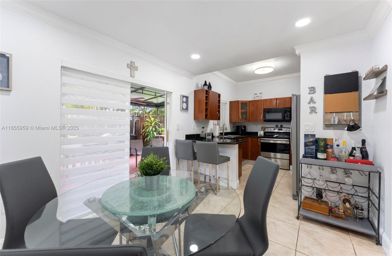 7423 Northwest 182nd Street Hialeah, FL 33015 - Photo 11 of 29 a dining room with furniture and a flat screen tv