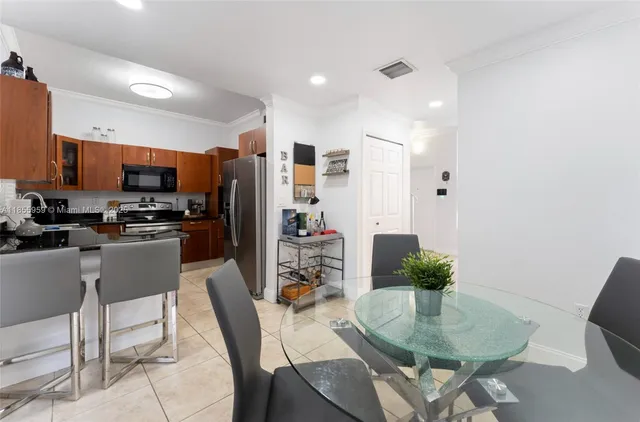 a kitchen with stainless steel appliances a dining table chairs and granite counter tops