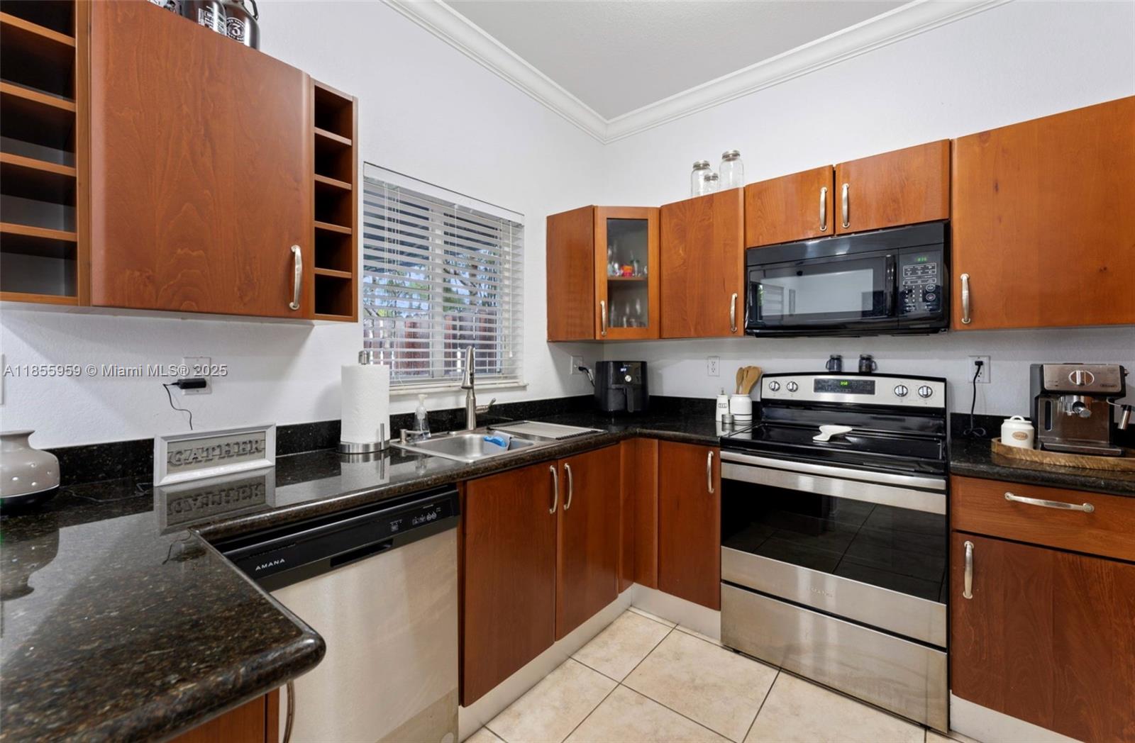 7423 Northwest 182nd Street Hialeah, FL 33015 - Photo 14 of 29 a kitchen with stainless steel appliances a stove sink microwave and cabinets