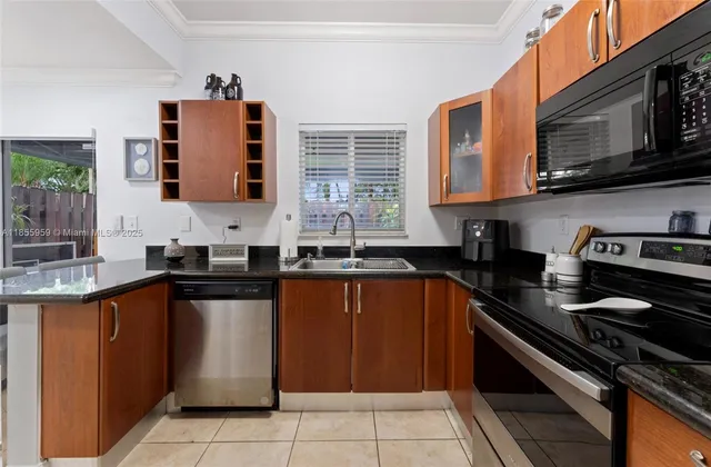 a kitchen with granite countertop a sink stove and cabinets