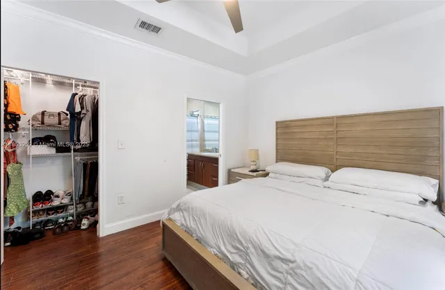 a bedroom with a bed wooden floor and window