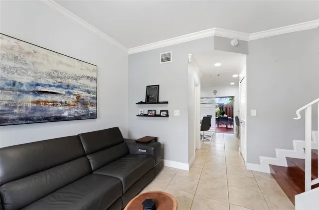 a living room with furniture and a view of kitchen