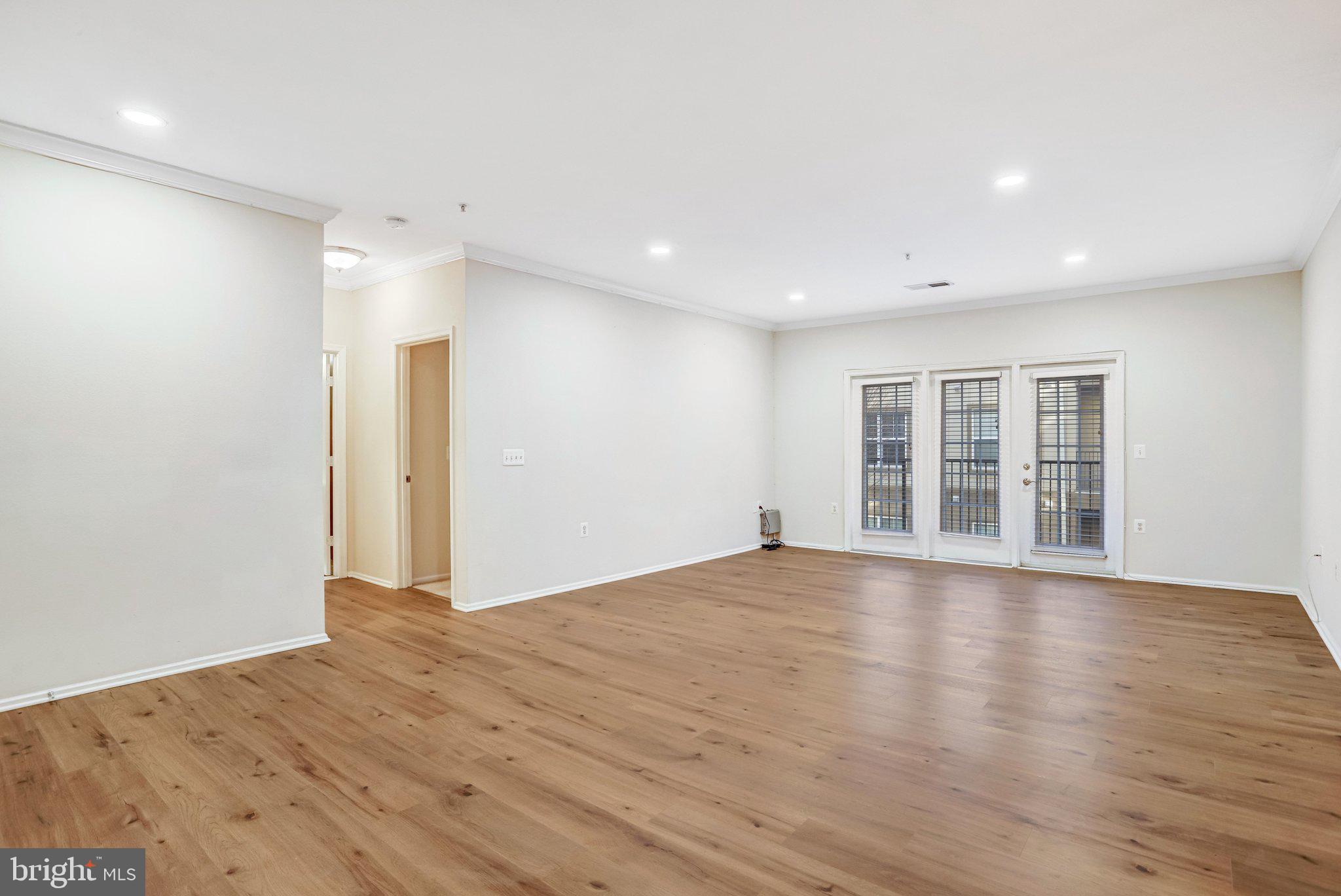 11800 Old Georgetown Road, Unit 1207 North Bethesda, MD 20852 - Photo 14 of 65 a view of an empty room with wooden floor and windows