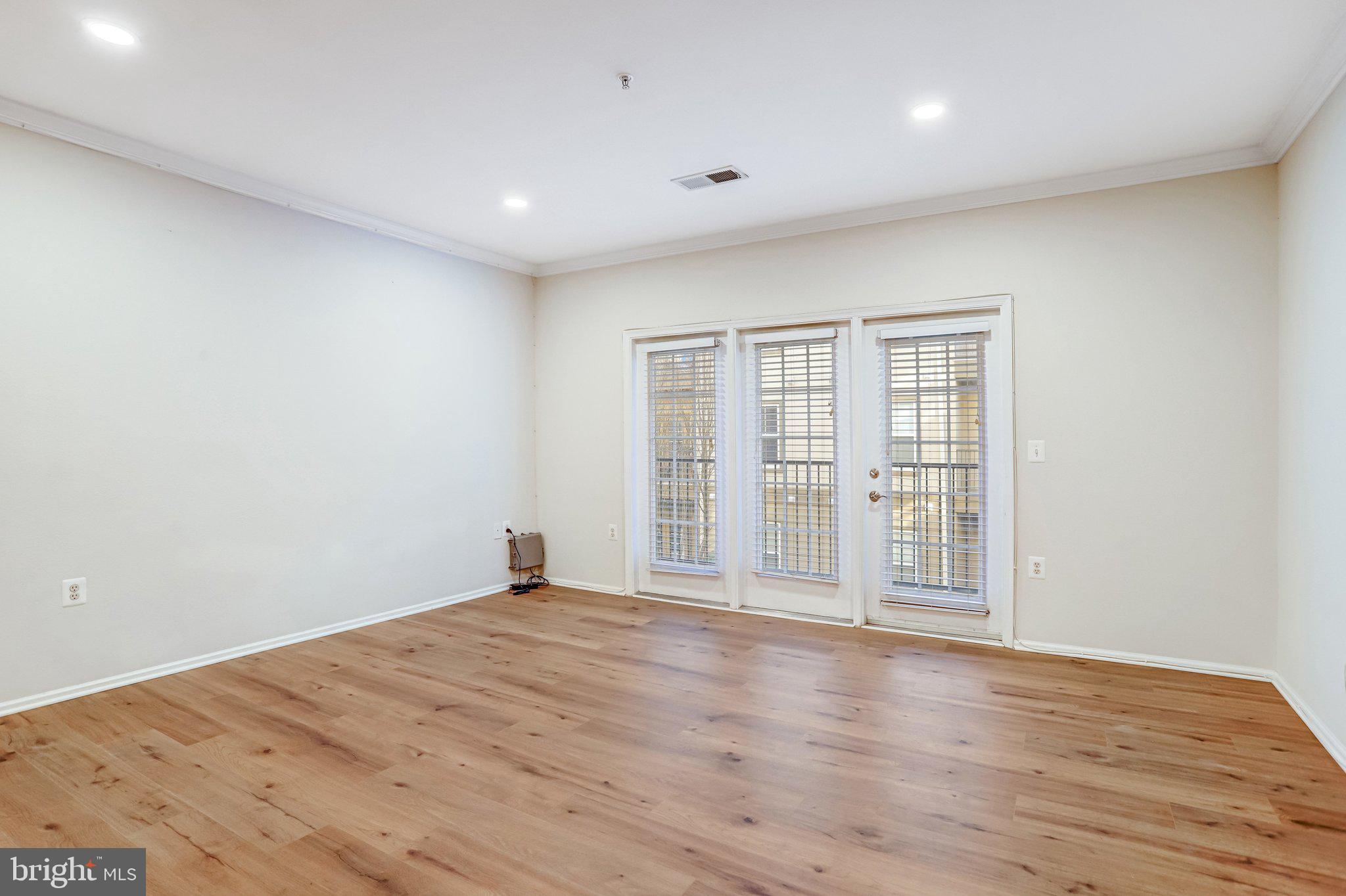11800 Old Georgetown Road, Unit 1207 North Bethesda, MD 20852 - Photo 15 of 65 a view of an empty room with wooden floor and fan