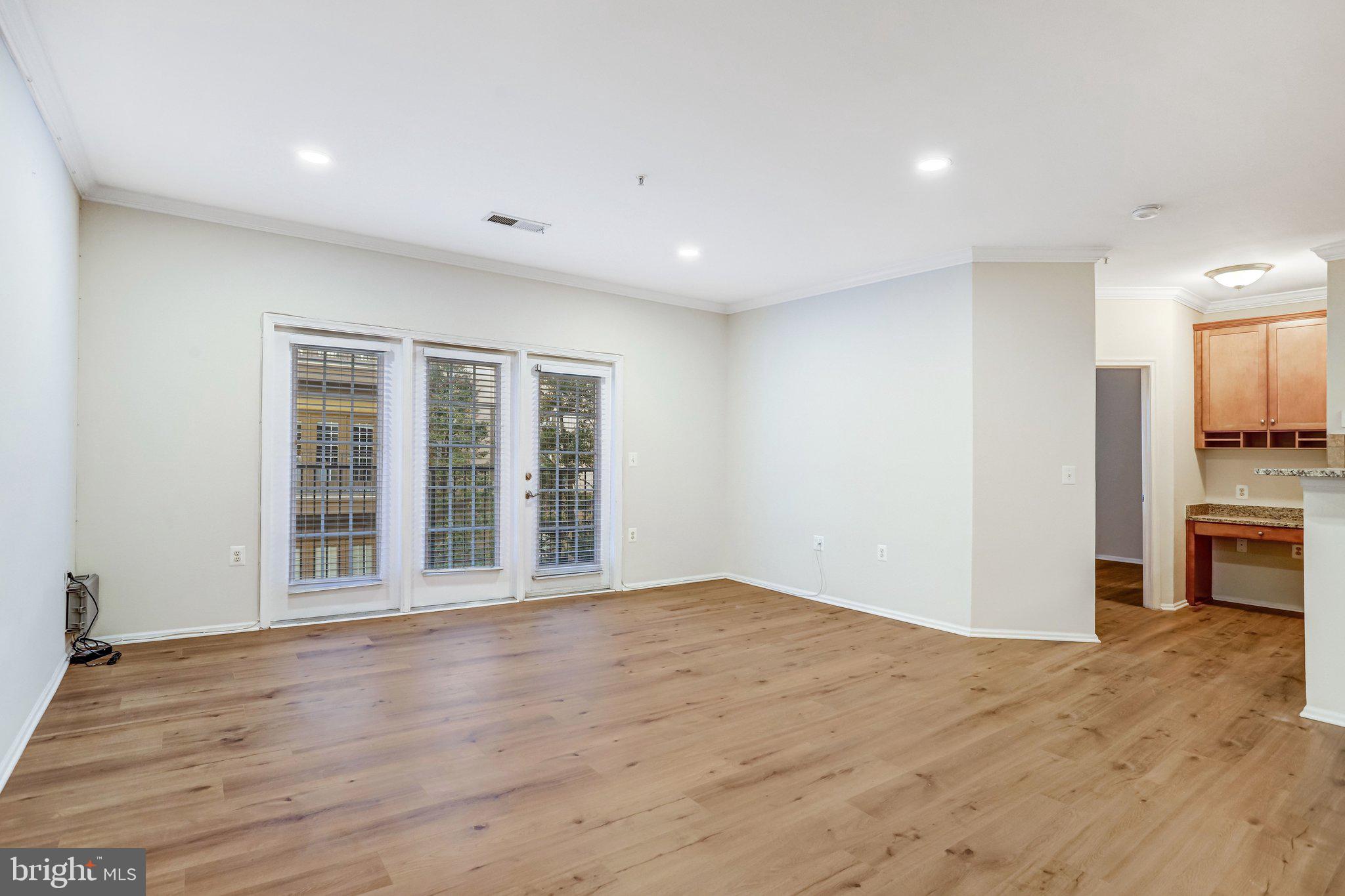 11800 Old Georgetown Road, Unit 1207 North Bethesda, MD 20852 - Photo 18 of 65 a view of an empty room with wooden floor and a window