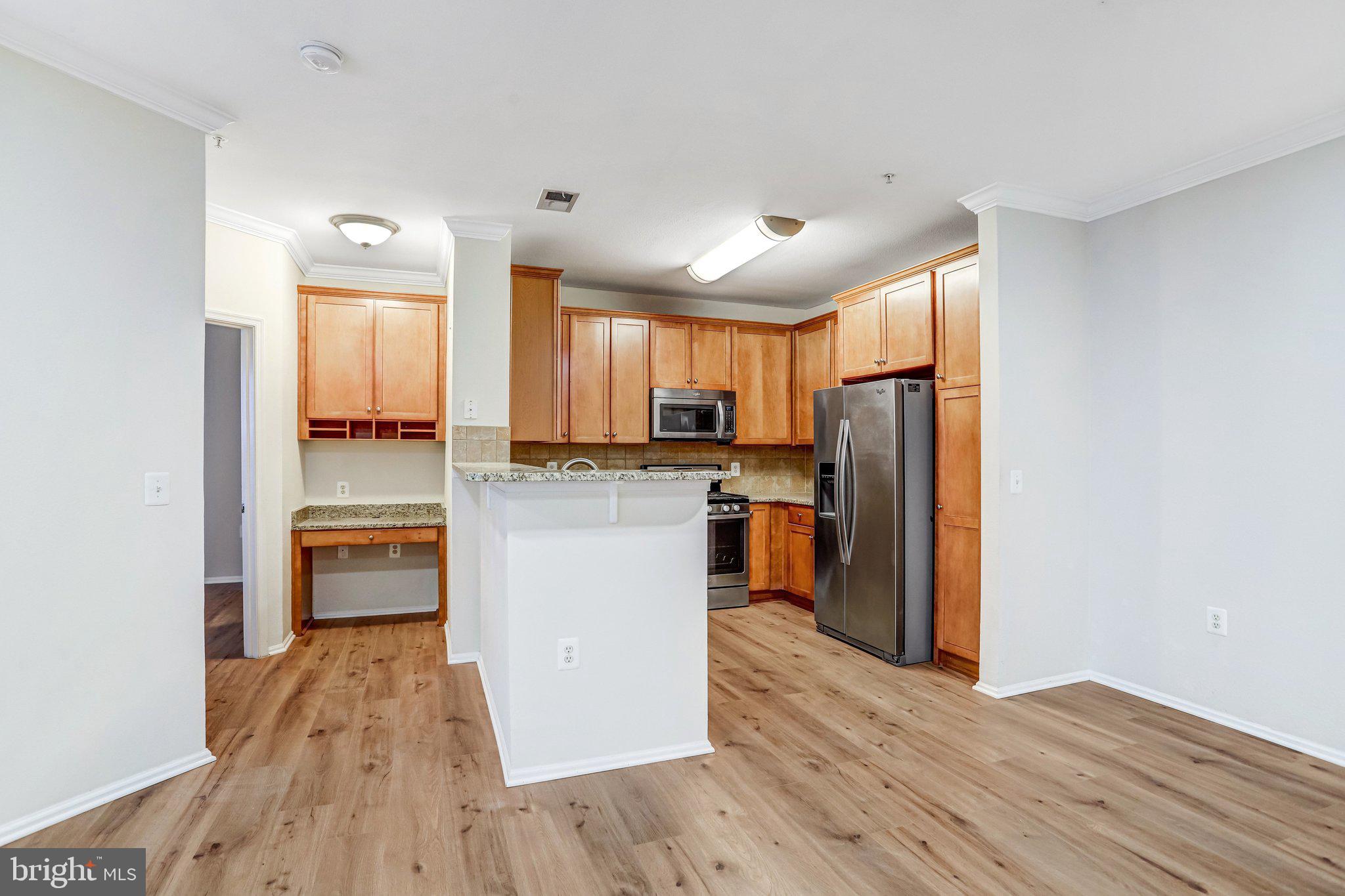 11800 Old Georgetown Road, Unit 1207 North Bethesda, MD 20852 - Photo 19 of 65 a kitchen with kitchen island wooden floors appliances and cabinets
