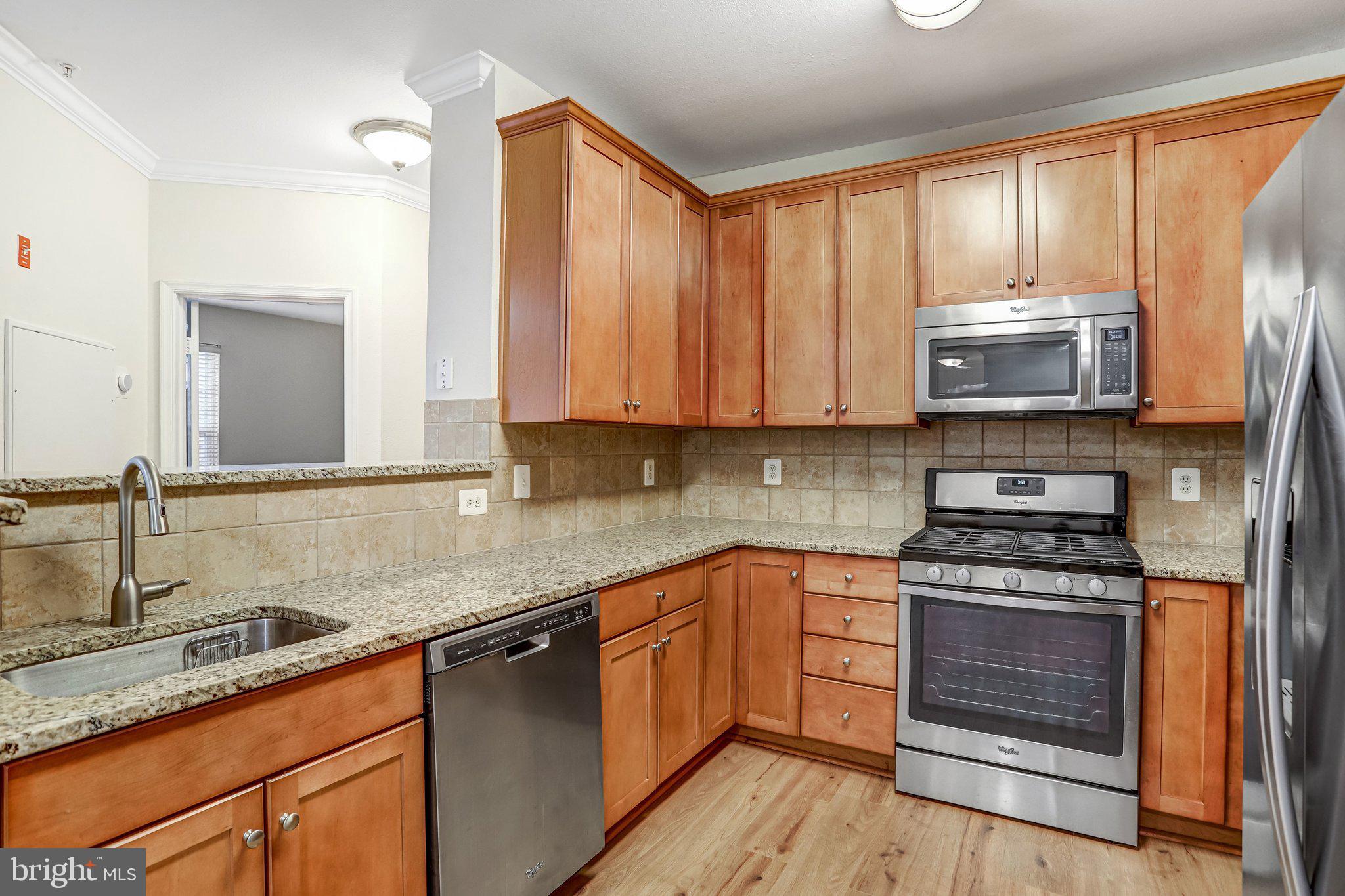 11800 Old Georgetown Road, Unit 1207 North Bethesda, MD 20852 - Photo 23 of 65 a kitchen with stainless steel appliances granite countertop a stove a sink and a microwave