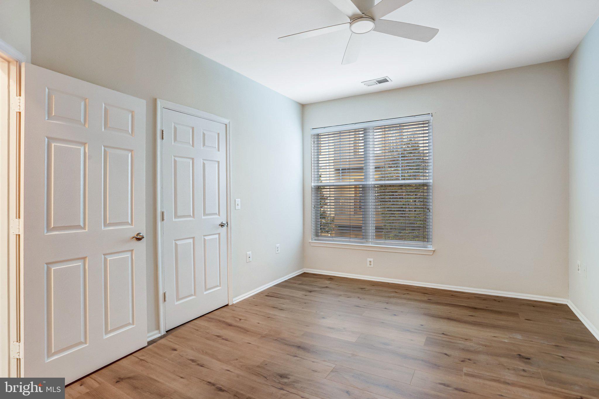 11800 Old Georgetown Road, Unit 1207 North Bethesda, MD 20852 - Photo 29 of 65 an empty room with wooden floor chandelier fan and windows
