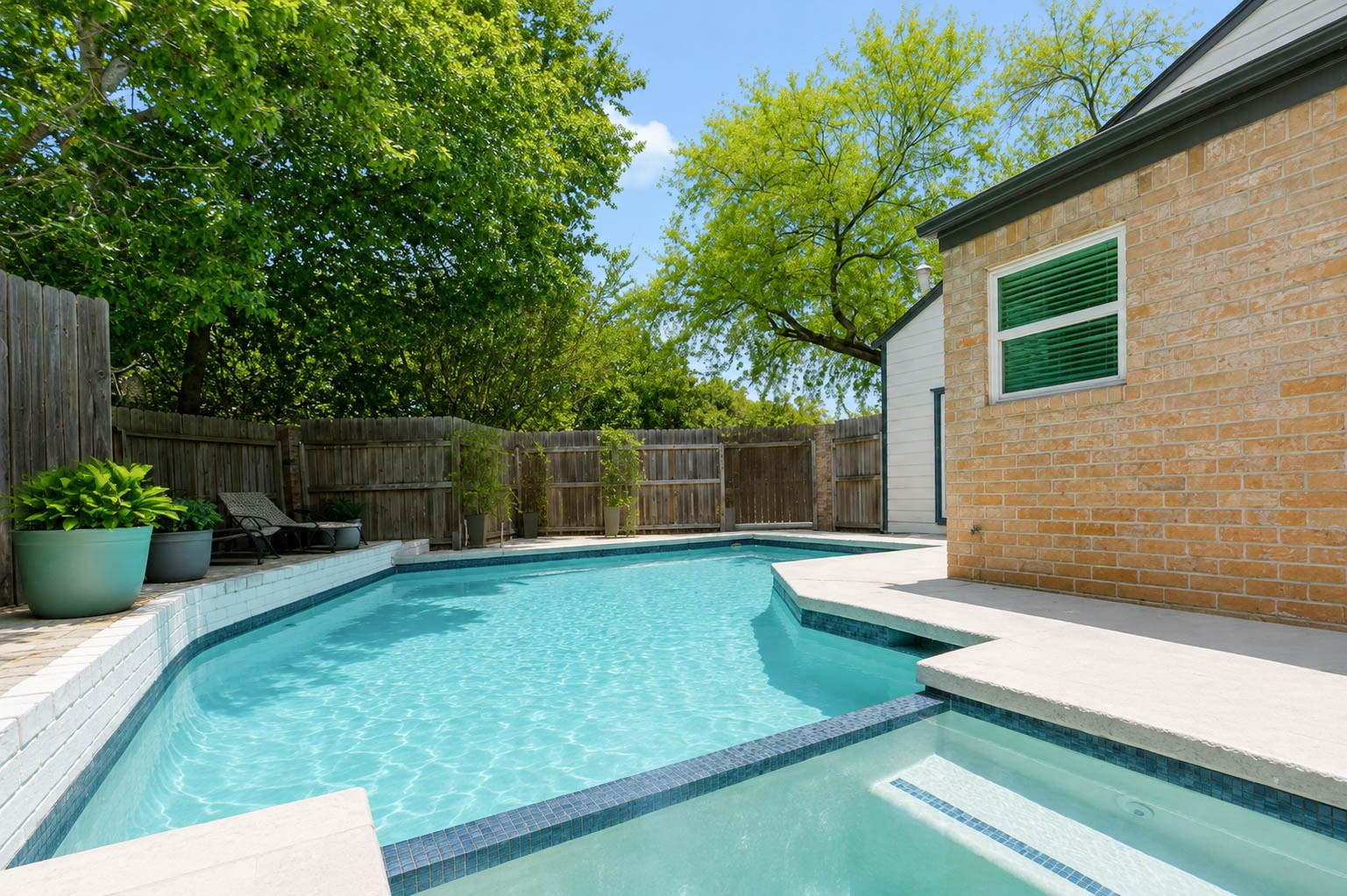 630 South Fry Road Katy, TX 77450 - Photo 44 of 48 Charming backyard oasis featuring a spacious patio perfect for outdoor relaxation, surrounded by lush grass and privacy fencing. The modern exterior showcases large windows for ample natural light.