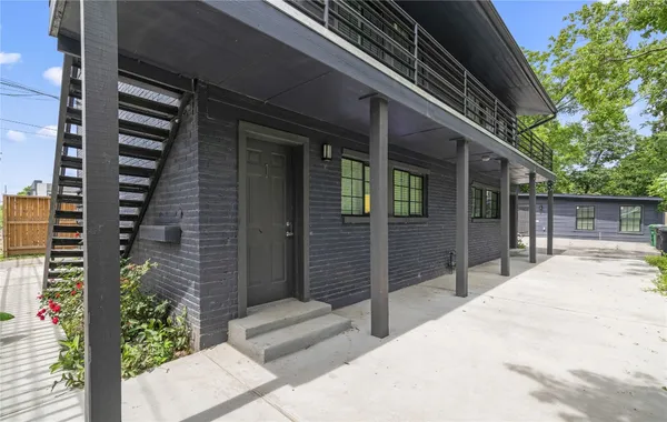 a view of backyard with large trees and wooden fence