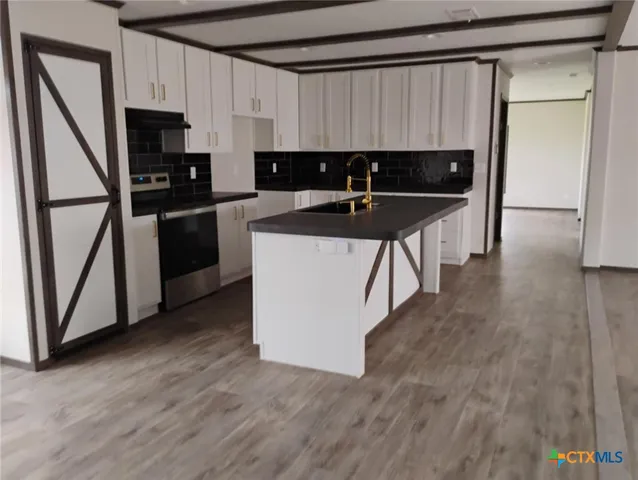 a kitchen with a sink a refrigerator and cabinets