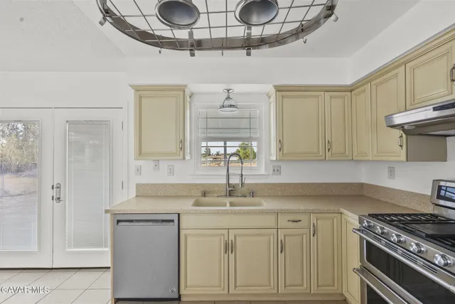 a kitchen with cabinets stainless steel appliances and a window